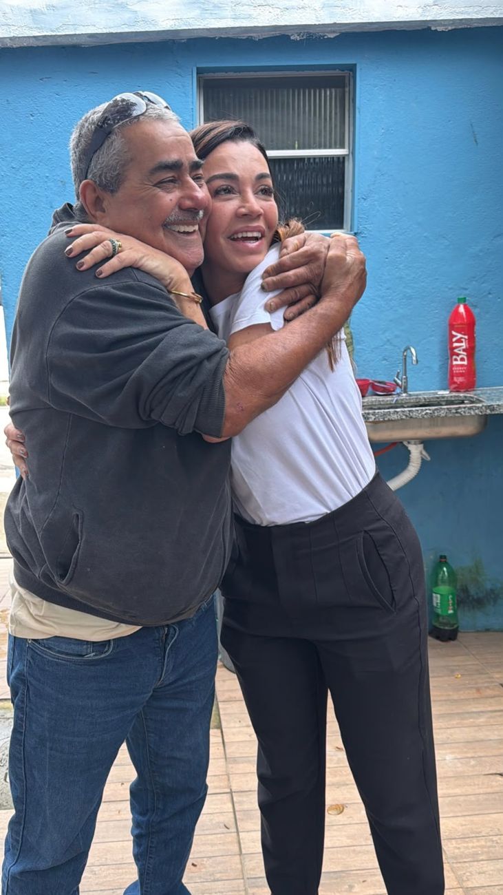 Morador abraça Kelaine, os dois sorrindo